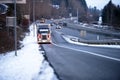 Big rig semi truck with light on roadside of winter snowy highway exit Royalty Free Stock Photo