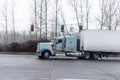 Big rig semi truck with long cab transporting dry van semi trailer turning on the traffic light road intersection Royalty Free Stock Photo