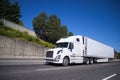 Big rig semi truck with reefer semi trailer going on highway wit