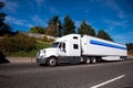 Big rig semi truck with refrigerator trailer going on the wide h