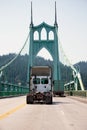 Big rig semi truck tractor driving by awesome St Johns bridge Royalty Free Stock Photo