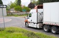 Big rig semi truck with semi trailer going on circle intersection of the street Royalty Free Stock Photo