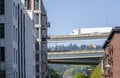 Big rig semi truck with semi trailer running on the overpass highway between high-rise buildings