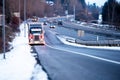 Big rig semi truck with semi trailer standing on the highway exit in snow winter weather