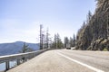 Big rig semi truck transporting cargo in dry van semi trailer running on the turning mountain highway road with rock mountain on Royalty Free Stock Photo