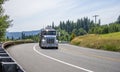 Big rig semi truck transporting flammable liquids and fuel in tank semi trailers running on the winding road Royalty Free Stock Photo