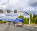 Big rig semi truck transporting oversized cargo on flat bed semi trailer running on the wide multiline highway road with Royalty Free Stock Photo