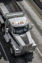 Big rig tip semi truck with empty dump trailer running on the road Royalty Free Stock Photo