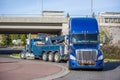 Big rig tow truck towing broken blue big rig semi truck tractor going under the bridge Royalty Free Stock Photo