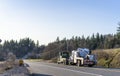 Big rig towing semi truck tow another broken big rig semi truck with application running on the road with hill and trees Royalty Free Stock Photo