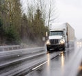 Big rig white diesel semi truck transporting container with commercial cargo running on the wet road at raining weather