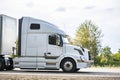 Big rig bonnet white long haul semi truck transporting cargo in dry van semi trailer driving on the highway road for timely Royalty Free Stock Photo