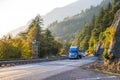 Big rigs semi trucks convoy turning on the sunny autumn road in