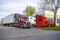 Big Rigs Semi Trucks congestion with semi trailers on the warehouse parking lot waiting for loading or unloading cargo in dock Royalty Free Stock Photo