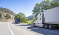 Big rigs semi trucks with semi trailers standing on the shoulder of the road take a break for truck driver rest Royalty Free Stock Photo