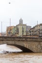 Big river water flowing on an old stone bridge in Girona skyline, Catalonia
