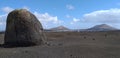 Big rock alone in the desert with volcans