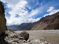 Big rock beside of the mud river in the mountain valley,