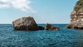 Big rock stacks in the calm blue sea against the blue sky on Corse island in France