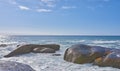 Big rocks in the ocean or sea water with a blue sky background. Beautiful landscape with a scenic view of the beach with Royalty Free Stock Photo