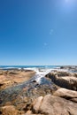 Big rocks in the ocean under a clear blue sky with copy space. Beautiful landscape of beach waves, tides and currents Royalty Free Stock Photo