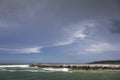 Big rocks and ominous storm clouds in s in Australiaky over water at breakwall on Wooli Wooli River Royalty Free Stock Photo