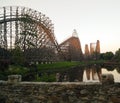 Big roller coaster in an amusement Park. High- speed ride on the rails at sunset. Royalty Free Stock Photo