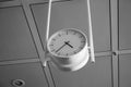 Big round analog clock handing from the ceiling inside an international airport Royalty Free Stock Photo