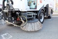 Big round broom of street sweeper with wide sweeping path and maintains contact with pavement on its own