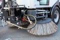 Big round brushes of street sweeper with wide sweeping path close up.Urban street cleaning.