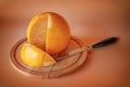 Big round cheese head on a wooden board with a sliced piece