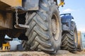 Big rubber wheels of soil grade tractor car earthmoving at road construction side. Close-up of a dirty loader wheel with a large Royalty Free Stock Photo