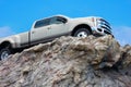 Big rugged pickup truck driving on a rocky cliff ledge