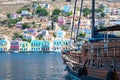 Big sailboat and colorful neoclassical houses in harbor town of Symi Symi Island, Greece