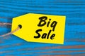 Big Sale tag on blue wooden background. Sales, discount, advertising, marketing price tags for clothes, furnishings