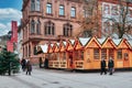 Big sales booth in small wooden sheds as part of traditional Christmas market on universiry square in city center of Heidelberg