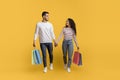 Big Sales. Happy Arab Couple Walking With Shopping Bags On Yellow Background Royalty Free Stock Photo