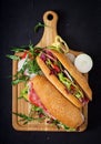 Big sandwich with ham, salami, tomato, cucumber and herbs. Royalty Free Stock Photo