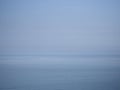 Big sea, small boat. Plain blue sky and horizon. Royalty Free Stock Photo