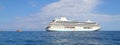 big seagoing passenger ship in the sea and next to it a small boat  blue sea and blue sky Royalty Free Stock Photo