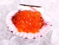 Big seashell filled with red caviar on ice Royalty Free Stock Photo
