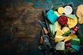 Big set of cheeses with snacks in a wooden box. On a black stone background. Royalty Free Stock Photo