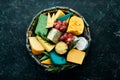 Big set of cheeses with snacks in a wooden box. On a black stone background. Royalty Free Stock Photo