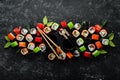 Big set of pieces of sushi rolls on black stone background. Top view. Royalty Free Stock Photo