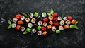 Big set of pieces of sushi rolls on black stone background. Top view. Royalty Free Stock Photo