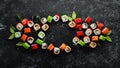 Big set of pieces of sushi rolls on black stone background. Top view. Royalty Free Stock Photo