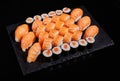 Big set of sashimi rolls with salmon, rolls California and Maki on a black flat board. Royalty Free Stock Photo