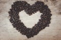 Big shape heart made from coffee beans on wooden table Royalty Free Stock Photo