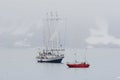 Big ship and small yacht in Arctic fjord Royalty Free Stock Photo