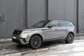Big silver grey British 4WD compact luxury crossover car Range Rover Velar parked in ice and snow